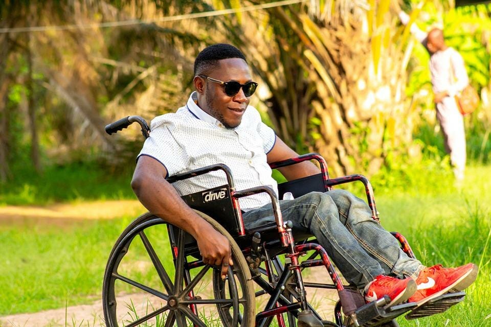 Uomo sulla sedia a rotelle con vestiario inclusivo